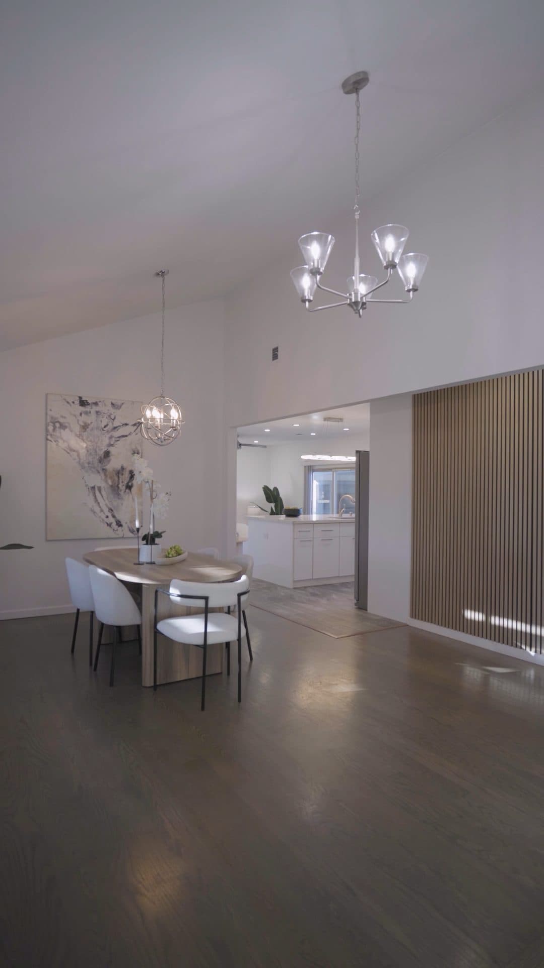 The dining area under the vaulted ceiling, opening to the kitchen.