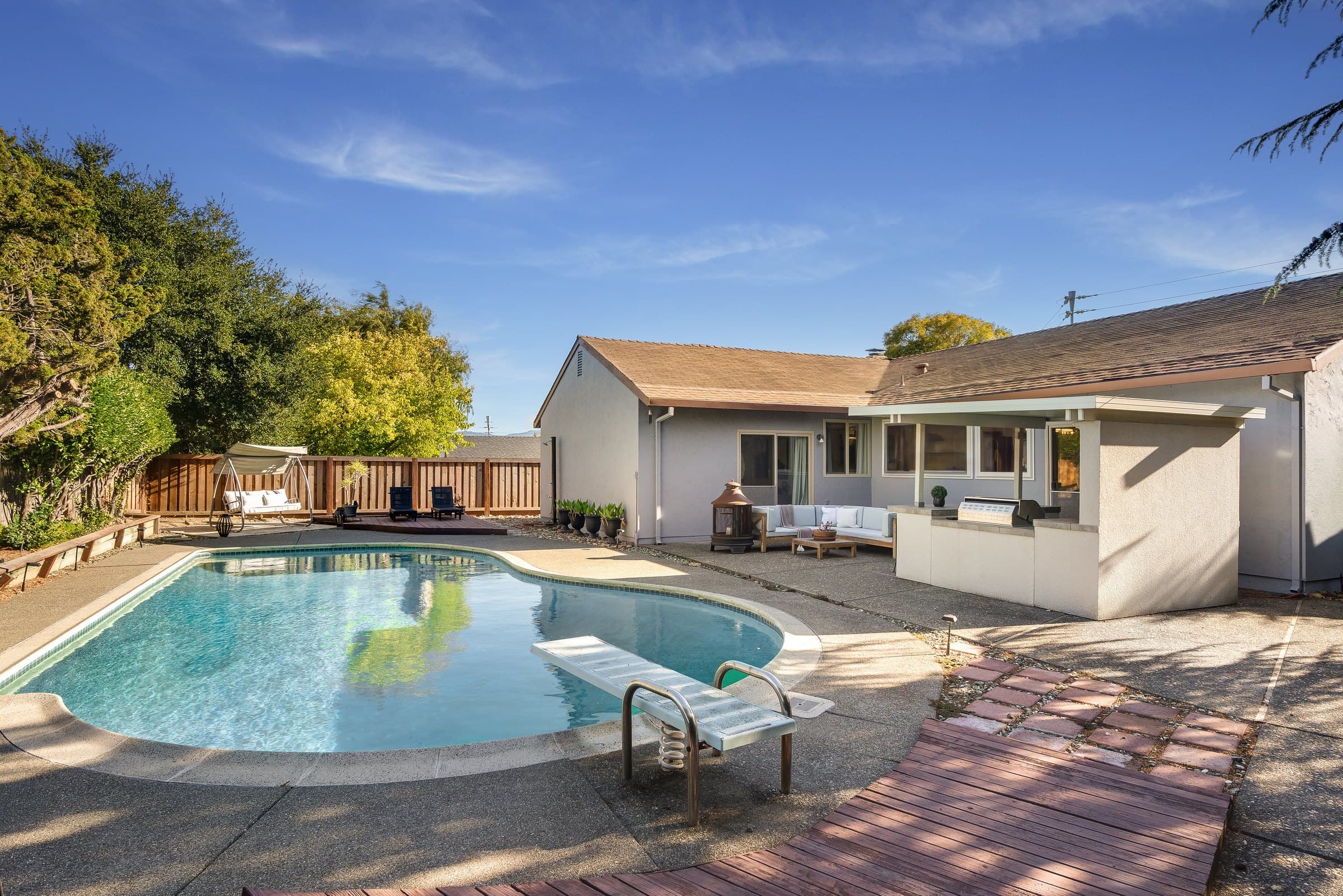 The fenced backyard with pool, spa, and kitchen.